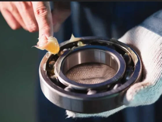 Mechanic applying grease to Kales semi-trailer wheel bearing for maintenance