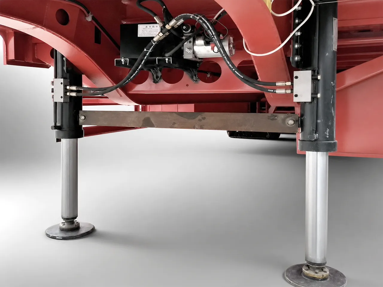 Hydraulic semi-trailer landing gear close-up showing cylinder-driven support-leg hardware